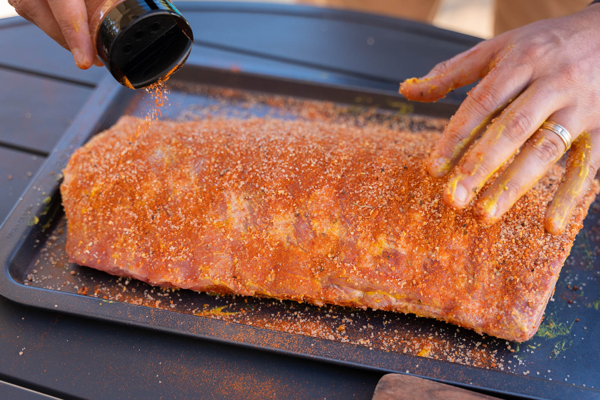 Luke applying olive oil as a binding agent to a wet rub