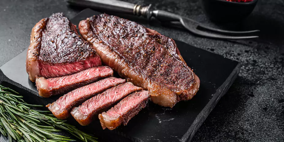 Grilled porterhouse (sirloin steak) on a black background