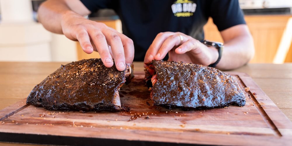 Luke showing the cross-section of pork ribs with the best spices for pork applied